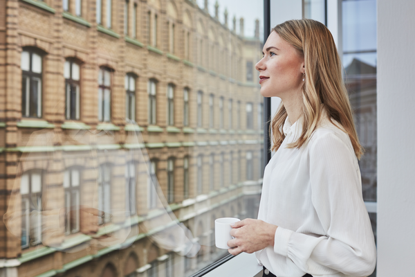 Woman standing by the window with cup Indoor air environment photo shoot session Aura